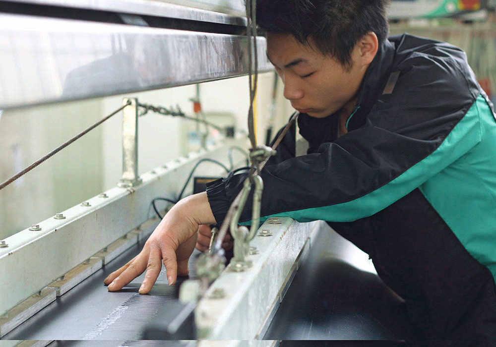 man servicing conveyor machinery